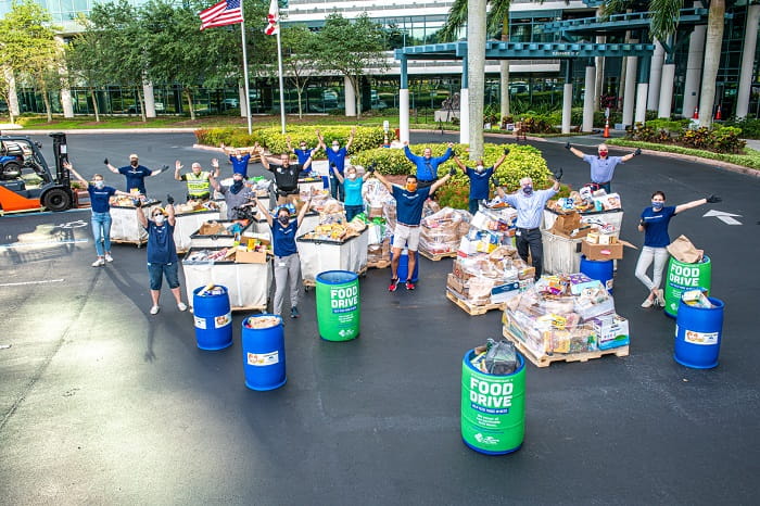Raymond James associates practice social distancing while volunteering to unload donations.
